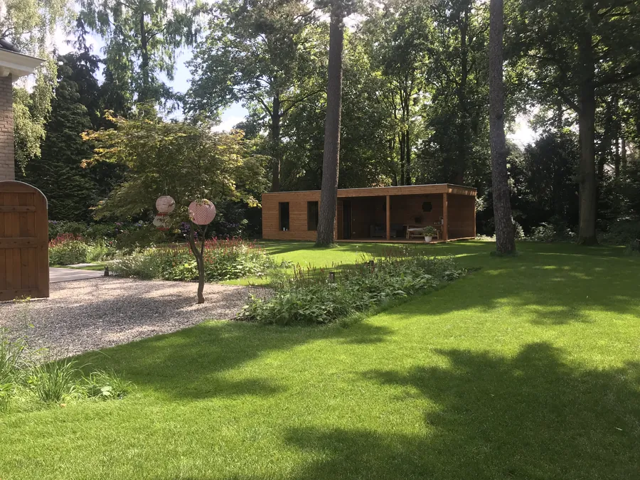 Houten schuur en tuinhuis achterin een grote bostuin