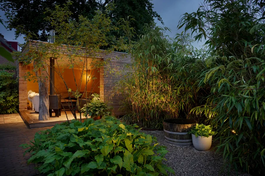 Gemetseld tuinhuis met openhaard bij avond