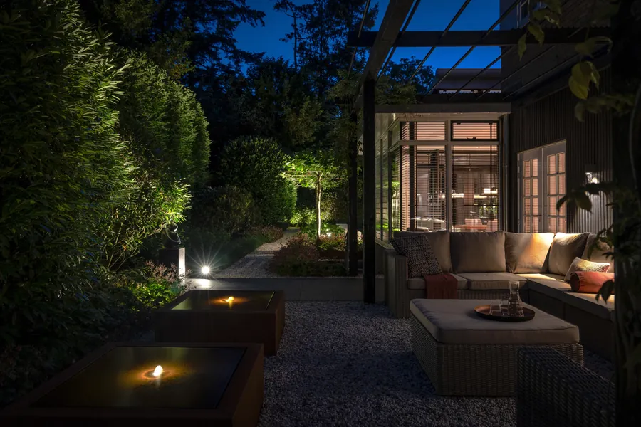 Avondverlichting in een villatuin met lounge en vuurtafels