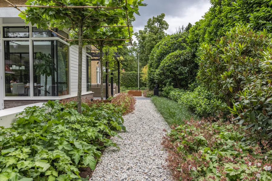 Grindpad langs de villa onder leilindes