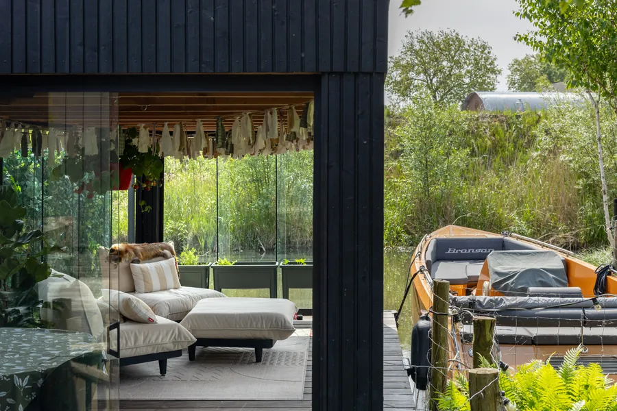 Loungebank in de tuinkamer met zicht op de sloep