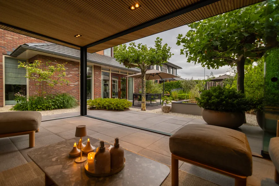 Lounge onder een overkapping met kaarsen en zicht op de tuin