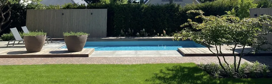Buitenzwembad met keramische rand en bloempotten