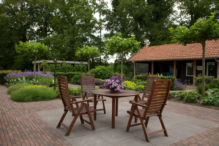 Veranda met pannendak naast een terras met tuinset